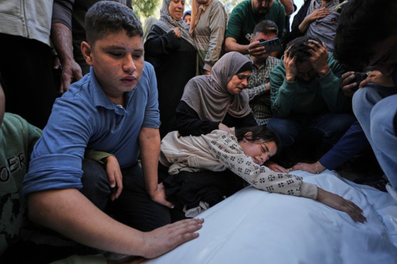 Dima Yassin llora sobre el cadáver de su madre, Dina Yassin, durante el funeral de sus padres, que murieron en un ataque israelí constra un departamento en la Ciudad de Gaza, el 20 de octubre de 2026. (AP Foto/Jehad Alshrafi)