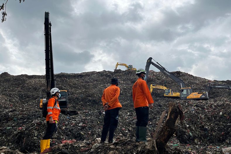 En eta imagen publicada por la Agencia Nacional Indonesia de Búsqueda y Rescate (BASARNAS) el lunes 9 de marzo de 2026, rescatistas inspeccionan el lugar de un alud de basura que mató a varias personas mientras se utiliza maquinaria pesada para buscar a las víctimas en un vertedero de Bantargebang, Java Occidental, Indonesia. (BASARNAS via AP)