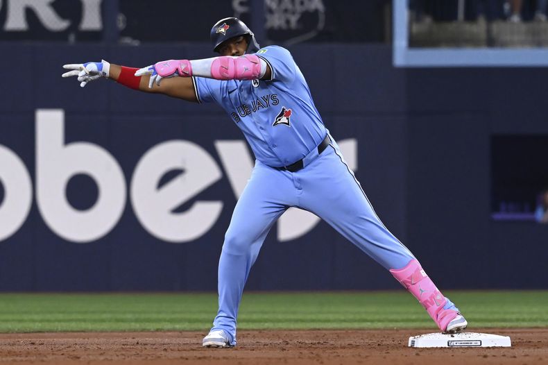 Vladimir Guerrero Jr (27), bateador desigando de los Azulejos de Toronto, celebra de cara al dugout después de batear un doblete frente a los Atléticos en la primera entrada del juego de béisbol de Grandes Ligas el domingo 1 de junio de 2025, en Toronto. (Jon Blacker/The Canadian Press vía AP)