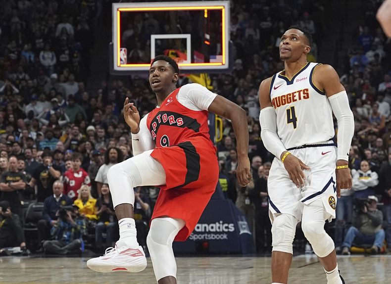 RJ Barrett, izquierda, de los Raptors de Toronto, sigue con la mirada el vuelo del balón de su último tiro a la canasta, con Russell Westbrook, de los Nuggets de Denver, como testigo después de tener una marca asfixiante para complicar el disparo, en la segunda mitad del juego de baloncesto de la NBA, el lunes 4 de noviembre de 2024, en Denver. (AP Foto/David Zalubowski)