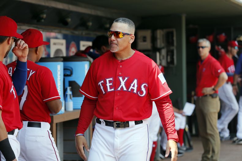 ARCHIVO - El coach de primera base de los Rangers de Texas Héctor Ortiz (4) camina en el dugout conversando con los jugadores durante un juego de béisbol ante los Angelinos de Los Ángeles el domingo 3 de septiembre de 2017, en Arlington, Texas. (AP Foto/Tony Gutierrez, Archivo)