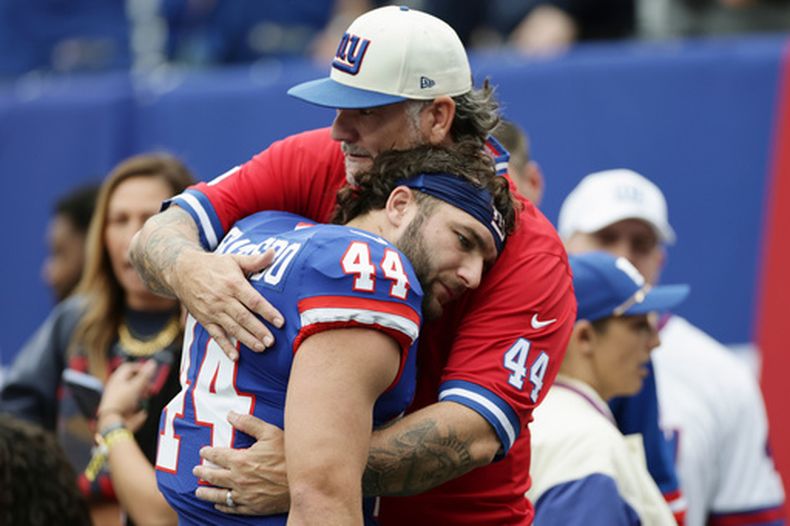 Cam Skattebo, corredor de los Giants de Nueva York, recibe un abrazo de su padre Leonard antes de un partido ante los Cardinals de Arizona, el domingo 4 de octubre de 2026 (AP Foto/Adam Hunger)