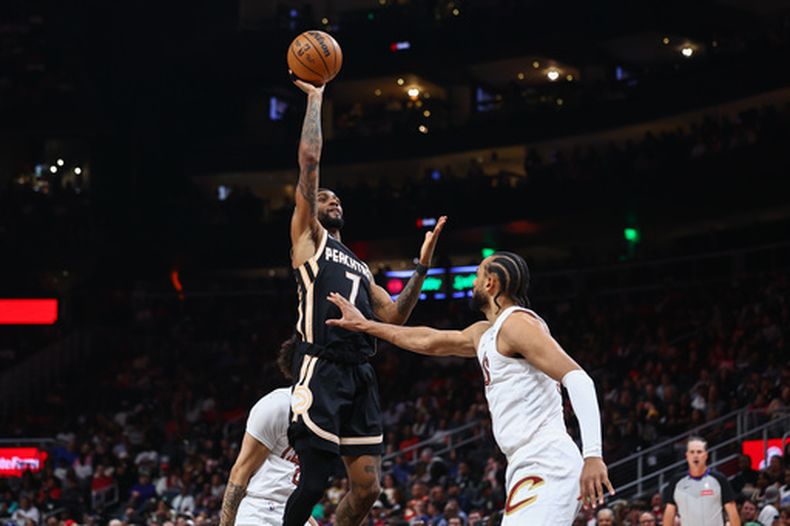 El base de los Hawks de Atlanta Nickeil Alexander-Walker lanza el balón frente al base de los Cavaliers de Cleveland Tyrese Proctor y el alero Olivier Sarr el viernes 10 de abril del 2026. (AP Foto/Colin Hubbard)