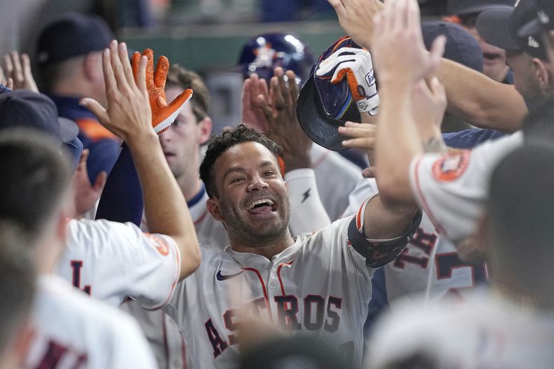José Altuve de los Astros de Houston celebra en el dugout después de batear un jonrón de tres carreras contra los Nacionales de Washington durante la segunda entrada de un partido de béisbol el miércoles 30 de julio de 2025, en Houston. (AP Photo/David J. Phillip)