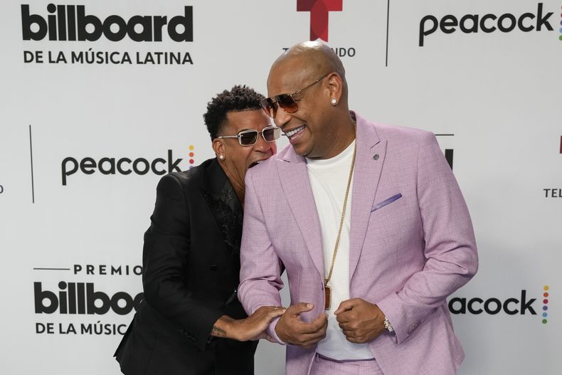 ARCHIVO - Randy Malcolm Martínez, izquierda, hace el gesto de morder el hombro de Alexander Delgado a la llegada del dúo cubano Gente de Zona a la alfombra azul de los Premios Billboard de la Música Latina en Coral Gables, Florida, el jueves 5 de octubre de 2023. Gente de Zona lanzó su álbum Demasiado el 18 de abril de 2024. (Foto AP/Rebecca Blackwell, archivo)