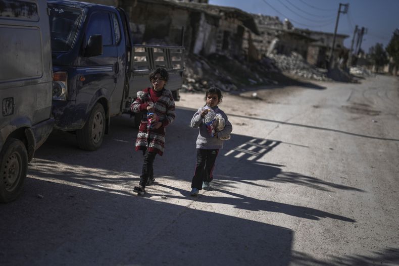 Dos niñas caminan al lado de viviendas destruidas en el pueblo de Tel Rifaat, en la región de Alepo en el norte de Siria, el 28 de enero del 2025. (AP foto/Khalil Hamra)