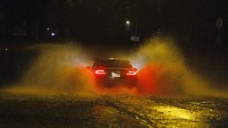 Un automóvil circula por una calle inundada en Filadelfia el 18 de diciembre de 2023. (Alejandro A. Alvarez/The Philadelphia Inquirer vía AP)