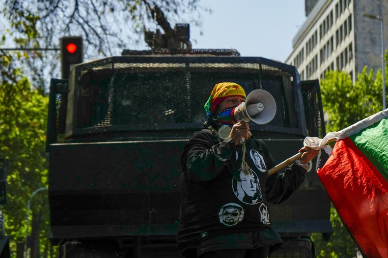 Un manifestante grita consignas contra la policía frente al cañón de agua durante una protesta para conmemorar el quinto aniversario de los disturbios más violentos desde el regreso de la democracia en Santiago, Chile, el viernes 18 de octubre de 2024. (AP Foto/Esteban Félix)