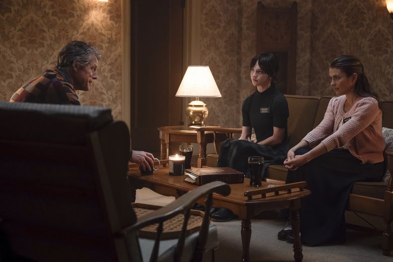 En esta imagen proporcionada por A24, Hugh Grant, de izquierda a derecha, Sophie Thatcher y Chloe East en una escena de Heretic. (Kimberley French/A24 via AP)