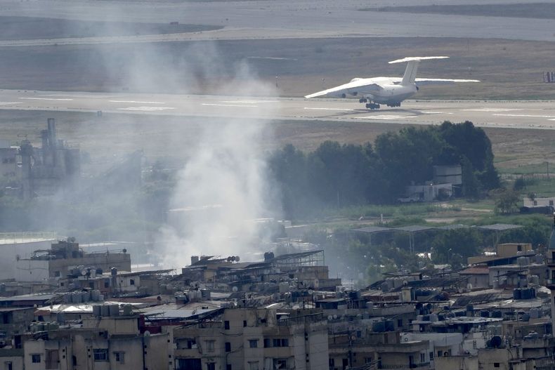 Un avión despega del aeropuerto internacional Rafik Hariri mientras sigue saliendo humo por un ataque israelí en Dahiyeh, Beirut, Líbano, el lunes 14 de octubre de 2024. (AP Foto/Hussein Malla)