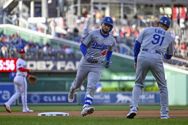 Andy Pagés es felicitado por el coach de tercera base de los Dodgers, Dino Ebel, por su cuadrangular solitario, durante la séptima entrada del juego de béisbol de Grandes Ligas contra los Nacionales de Washington, el miércoles 9 de abril de 2025, en Washington. (AP Foto/John McDonnell)