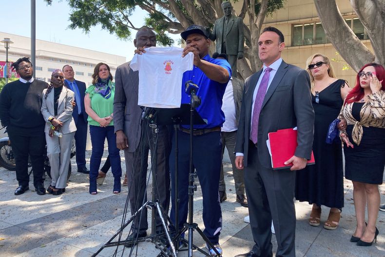 ARCHIVO - Jonathan Wright, de 39 años, sostiene la camiseta que le dieron cuando llegó al Centro Infantil MacLaren en El Monte cuando tenía 8 años, en una conferencia de prensa en Los Ángeles, el 9 de junio de 2022. (AP Foto/Christopher Weber, Archivo)