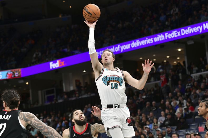 Luke Kennard, base de los Grizzlies de Memphis, dispara frente a Fred VanVleet, de los Rockets de Houston, el jueves 30 de enero de 2025 (AP Foto/Brandon Dill)