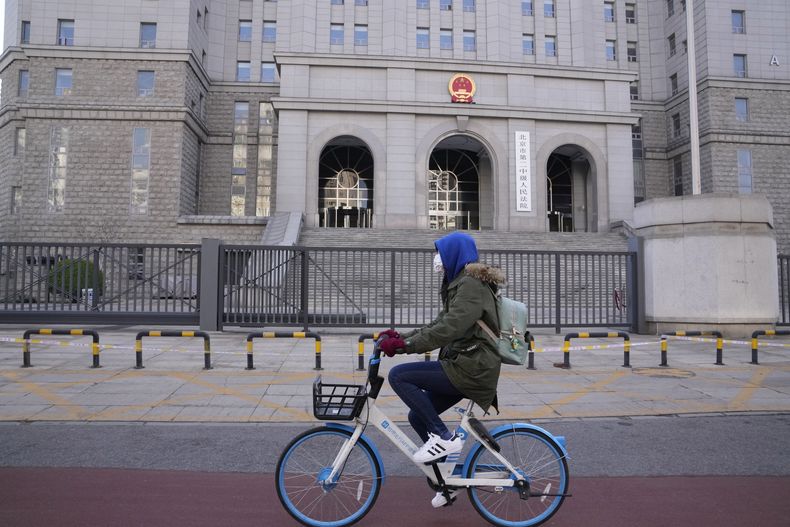 ARCHIVO - Un ciclista pasa por delante del Tribunal Popular Intermedio Número 2 de Beijing, el 31 de marzo de 2022, en Beijing. (AP Foto/Ng Han Guan, archivo)
