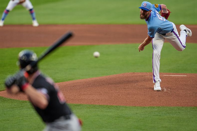 Chris Sale, derecha, estelar abridor de los Bravos de Atlanta, trabaja frente a Chase DeLauter (24), de los Guardianes de Cleveland, en la primera entrada del juego de béisbol de las Grandes Ligas, el domingo 12 de abril de 2026, en Atlanta. (AP Foto/Mike Stewart)