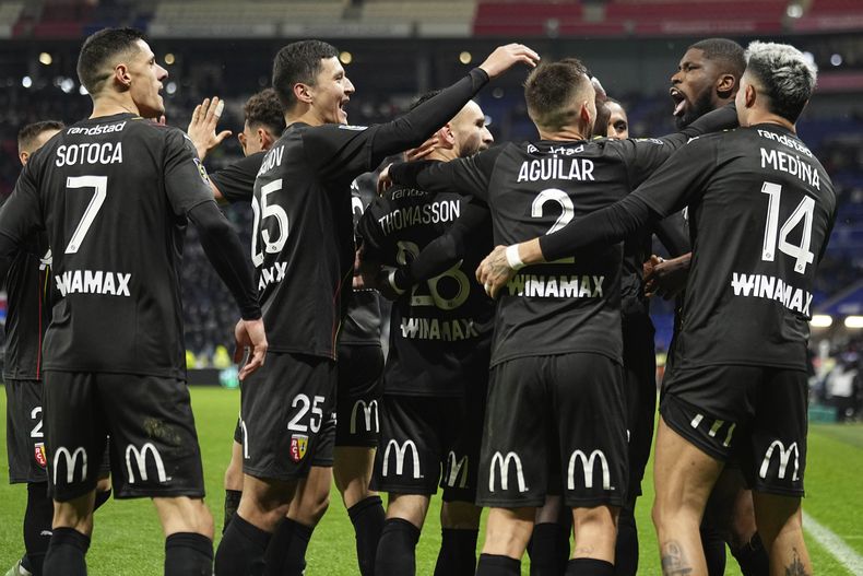 Kevin Danso celebra con sus compañeros de Lens tras marcar un gol ante Lyon en el partido de la liga francesa, el domingo 3 de marzo de 2024. (AP Foto/Laurent Cipriani)