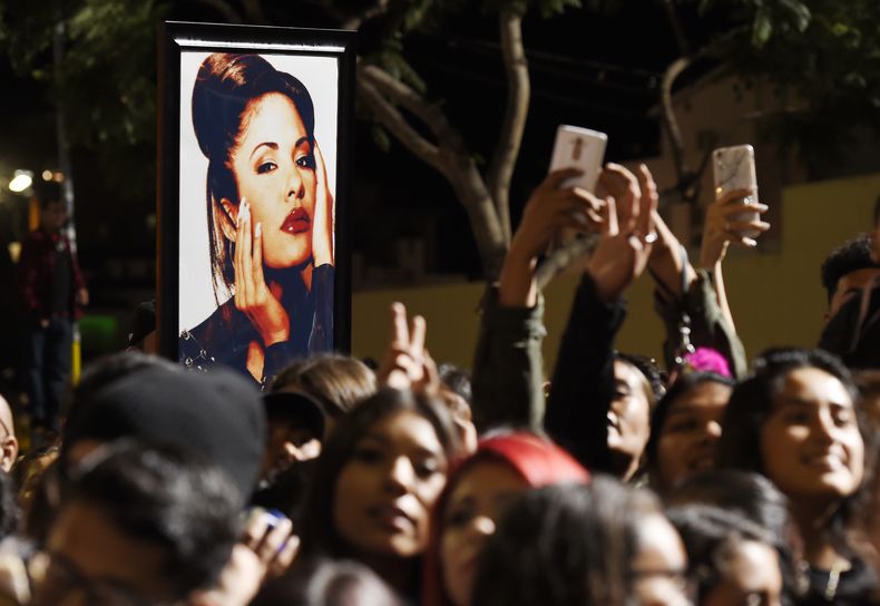 ARCHIVO - Un retrato de la fallecida cantante Selena Quintanilla se ve entre la multitud después de una ceremonia póstuma para develar la estrella de Quintanilla en el Paseo de la Fama de Hollywood el viernes 3 de noviembre de 2017, en Los Ángeles. (Foto Chris Pizzello/Invision/AP, archivo)