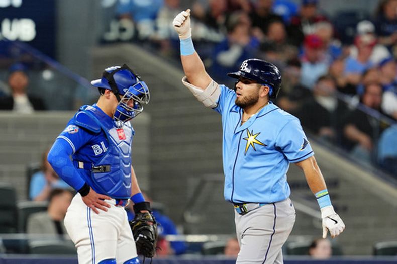Brandon Valenzuela, izquierda, receptor de los Azulejos de Toronto, está cabizbajo mientras Jonathan Aranda, derecha, de los Rays de Tampa Bay celebra después de batear un jonrón solitario durante la quinta entrada del juego de béisbol de Grandes Ligas del lunes 11 de mayo de 2026, en Toronto. (Frank Gunn/The Canadian Press via AP)