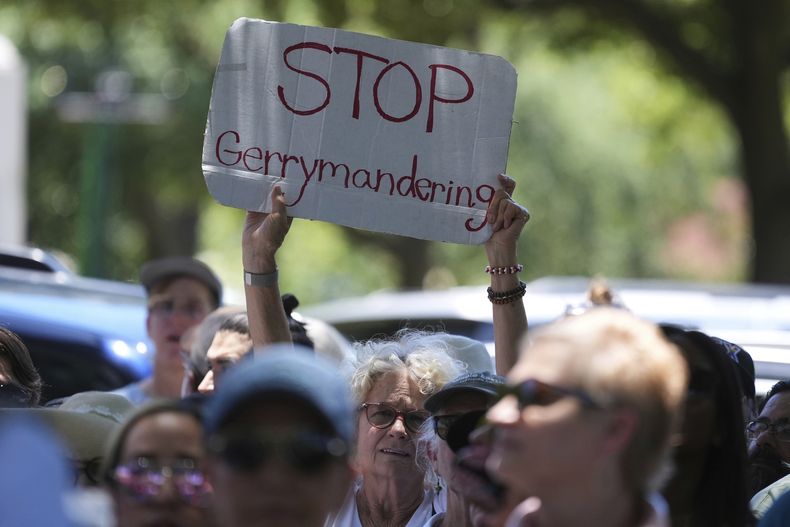 Una mujer sostiene una pancarta durante una protesta contra la audiencias de redistribución de mapas electorales en el Capitolio de Texas, el jueves 24 de julio de 2025, en Austin, Texas. (AP Foto/Eric Gay)
