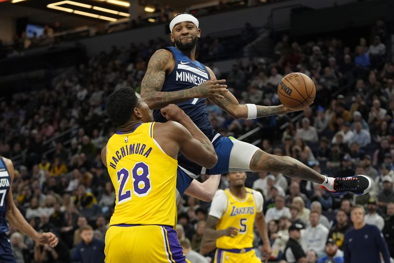 Nickeil Alexander-Walker, arriba, de los Timberwolves de Minnesota, busca pasar la pelota mientras Rui Hachimura (28), de los Lakers de Los Ángeles, defiende durante la primera mitad del juego de baloncesto de la NBA, el viernes 13 de diciembre de 2024, en Minneapolis. (AP Foto/Abbie Parr)