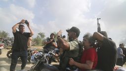 Palestinos trasladan a una civil israelí capturada, en el centro, desde el kibbutz Kfar Azza a la Franja de Gaza, el sábado 7 de octubre de 2023. El grupo Hamas, que gobierna la Franja de Gaza, realizó un ataque sin precedentes desde varios puntos contra Israel al amanecer del sábado, y lanzó miles de cohetes mientras docenas de combatientes se infiltraban en la fortificada frontera por aire, tierra y mar y tomaban al país por sorpresa en un importante feriado. (AP Foto)