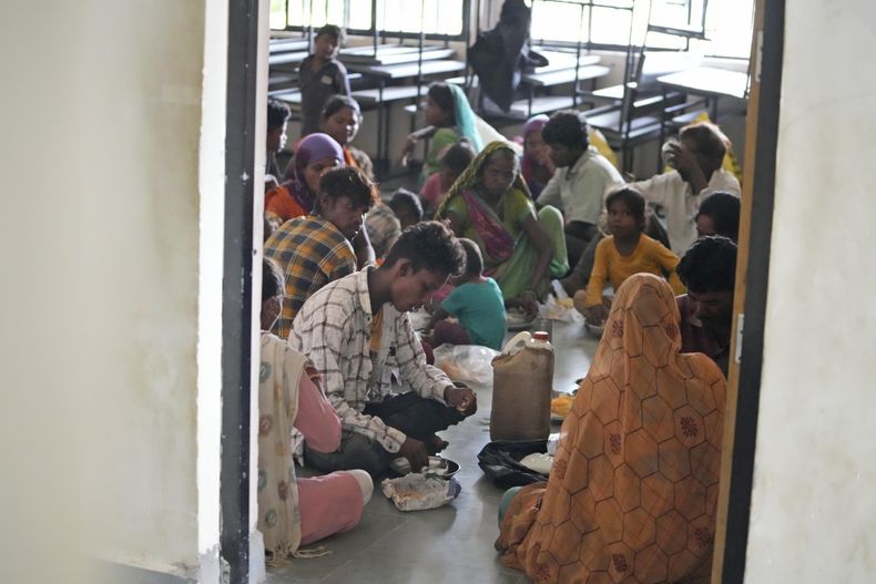Gente evacuada de un pueblo cerca de Jakhau come en un refugio en Naliya, en el distrito de Kutch, India, el miércoles 14 de junio de 2023. Se esperaba que el ciclón Biparjoy tocara tierra cerca del puerto de Jakhau y fuera la tormenta más fuerte en golpear el oeste de India y Pakistán desde 2021. (AP Foto/Ajit Solanki)