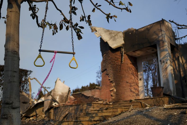 Un columpio cuelga de un árbol delante de una vivienda dañada por el fuego, en el vecindario de Pacific Palisades, en Los Angeles, el 10 de enero de 2025. (AP Foto/Eric Thayer)