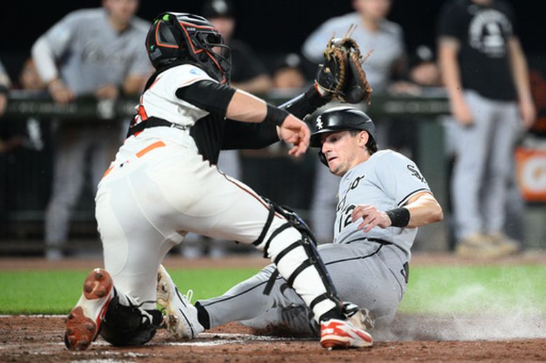 Colson Montgomery, derecha, de los Medias Blancas de Chicago, se barre en el plato para anotar ante el intento de Adley Rutschman, izquierda, receptor de los Orioles de Baltimore, de ponerlo fuera durante la octava entrada del juego de béisbol de Grandes Ligas, el lunes 29 de junio de 2026, en Baltimore. (AP Foto/Nick Wass)