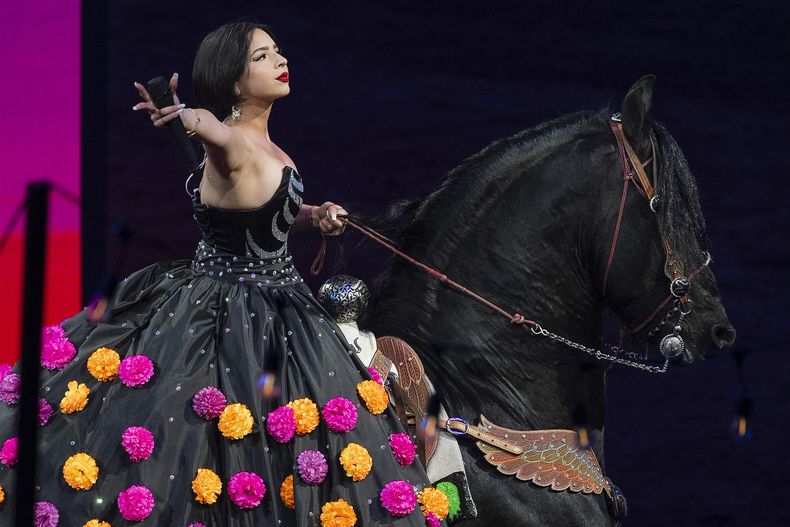 Ángela Aguilar, hija de Pepe Aguilar, monta un caballo al cantar en el espectáculo Jaripeo hasta los huesos tour 2024 en el Honda Center en Anaheim, California, el viernes 29 de marzo de 2024. El espectáculo rinde homenaje al Día de Muertos, una conocida celebración mexicana. (Foto AP/Damian Dovarganes)