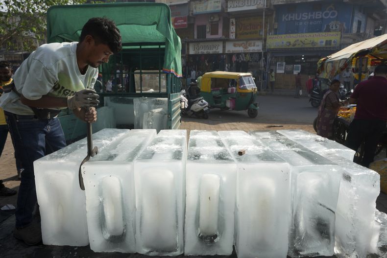 ARCHIVO - Un hombre coloca bloques de hielo en un puesto para su venta, en Ahmedabad, India, el 2 de abril de 2025. (AP Foto/Ajit Solanki, archivo)
