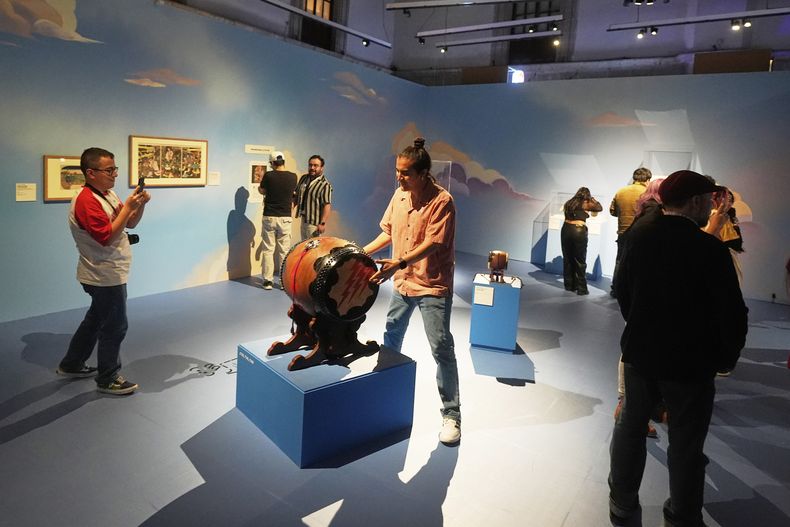 Un visitante toca un tambor durante la inauguración de la exposición Japón: Del mito al manga, en el Museo Franz Mayer, en la Ciudad de México, el jueves 7 de agosto de 2025. (Foto AP/Fernando Llano)