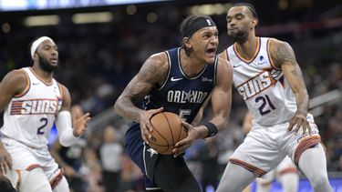 El alero del Magic de Orlando Paolo Banchero avanza hacia la canasta mientras lo defiende el alero de los Suns de Phoenix Keita Bates-Diop y Josh Okogie observa en el encuentro de la NBA del domingo 28 de enero del 2024. (AP Foto/Phelan M. Ebenhack)