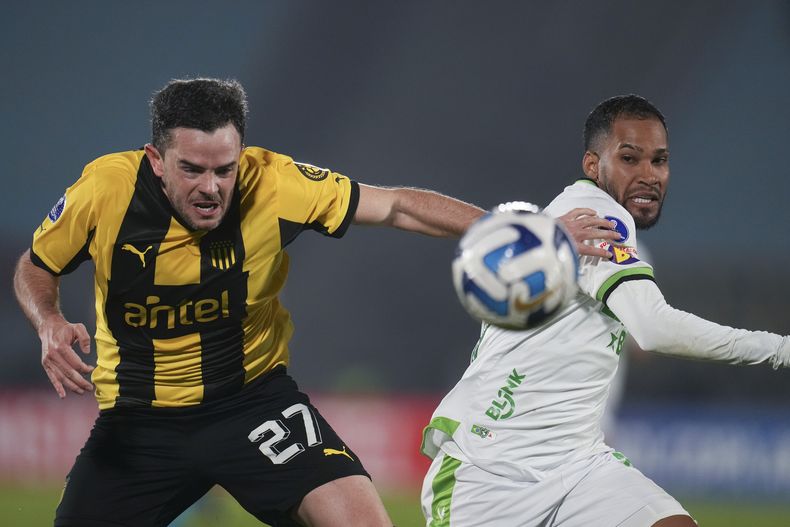 Everaldo (derecha) del América Mineiro de Brasil, y Lucas Hernández de Peñarol de Uruguay pugnan por el balón en el partido de la Copa Sudamericana, el jueves 29 de junio de 2023, en Montevideo. (AP Foto/Matilde Campodónico)