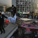 Miembros del Cuerpo de Investigación Científica, Penal y Criminalística de Venezuela recuperan el cuerpo de una de las dos hijas de Yolimar Torres, a quien la familia encontró entre los escombros de un edificio derrumbado por los dos terremotos, en La Guaira, Venezuela, el miércoles 15 de julio de 2026. (Foto AP/Ariana Cubillos)
