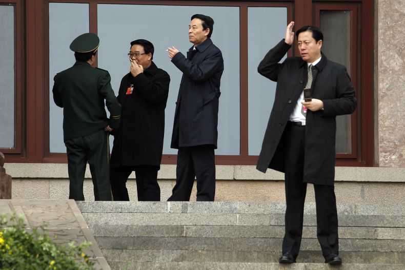 Delegados chinos en una foto de archivo del 4 de marzo del 2012 fuman en la puerta del Gran Sal&oacute;n del Pueblo mientras asisten a una reuni&oacute;n en Beijing, China. China pidi&oacute; a sus funcionarios que sean los primeros en adherirse a la proh