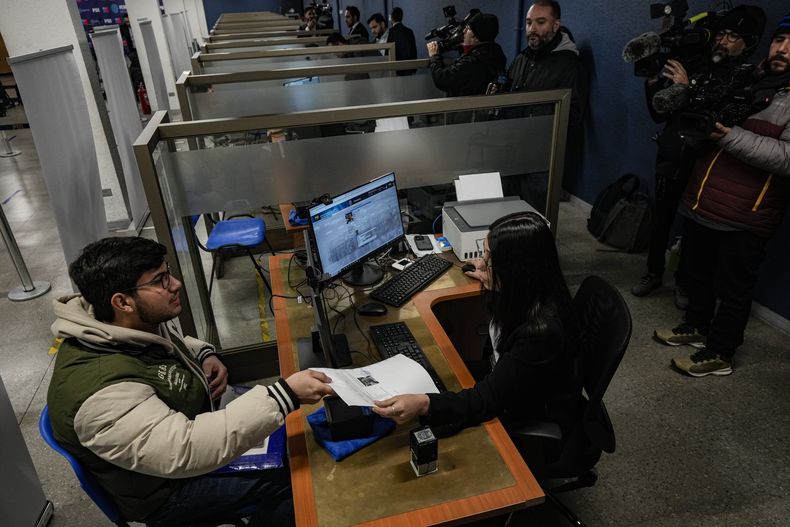 El migrante venezolano Emanuel Palmar participa en un registro biométrico en una oficina de investigaciones policiales en Santiago, Chile, el martes 11 de julio de 2023. (AP Foto/Esteban Felix)