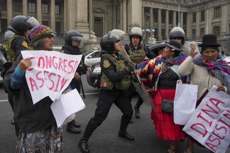 Manifestantes antigubernamentales intentan pasar a través de la policía que los bloquea afuera del Palacio de Justicia mientras intentan llegar al Congreso, donde la presidenta peruana Dina Boluarte daba su segundo discurso sobre el Estado de la Nación en el Día de la Independencia en Lima, Perú, el domingo 28 de julio de 2024. (AP Foto/Guadalupe Pardo)