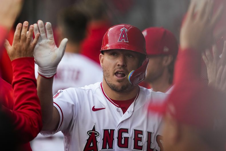 Mike Trout (6), de los Angelinos de Los Ángeles, celebra en la banca tras anotar en un triple de Brandon Drury en el primer inning del juego de la MLB que enfrentó a su equipo con los Atléticos de Oakland, en Anaheim, California, el 25 de abril de 2023. (AP Foto/Ashley Landis)