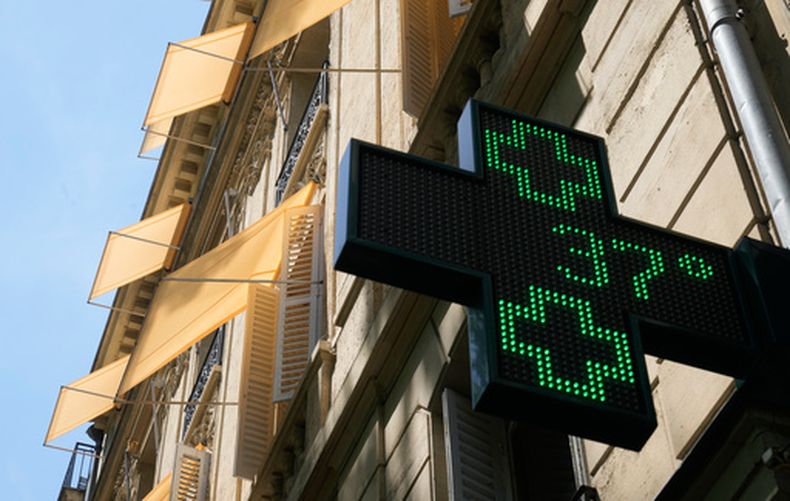 Un cartel luminoso ante una farmacia marca 37 grados Celsius (98,6 grados Fahrenheit) en París, el domingo 21 de junio de 2026. (AP Foto/Michel Euler)