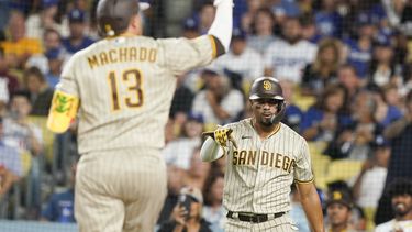 Juan Soto (derecha), de los Padres de San Diego, hace un gesto al bateador designado Manny Machado (16) tras anotar en un jonrón de dos carreras de Machado durante el sexto inning del juego de la MLB que enfrentó a su equipo con los Dodgers de Los Ángeles, el 11 de septiembre de 2023, en Los Ángeles. (AP Foto/Ryan Sun)