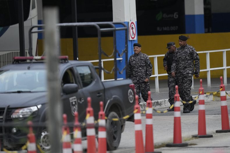 Policías caminan en una terminal de autobuses donde un hombre armado lesionó a dos personas y tomó a otras 17 como rehenes en Río de Janeiro, Brasil, el martes 12 de marzo de 2024. (AP Foto/Silvia Izquierdo)