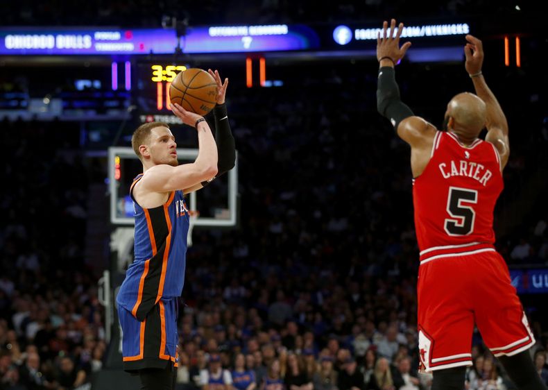 El base de los Knicks de Nueva York Donte DiVincenzo se prepara para lanzar un triple frente a Jevon Carter de los Bulls de Chicago el domingo 14 de abril del 2024. (AP Foto/John Munson)