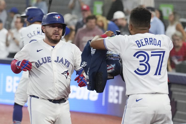 El mexicano, Alejandro Kirk, de los Azulejos de Toronto recibe la chaqueta de cuadrangular por parte del dominicano Steward Berroa luego de conectar un jonrón de tres carreras frente a los Orioles de Baltimore, en la sexta entrada del juego de béisbol en Toronto, el martes 6 de agosto de 2024. (Chris Young/The Canadian Press via AP)