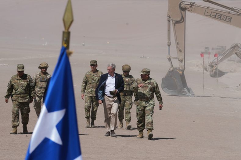 El presidente chileno José Antonio Kast camina junto a las excavadoras a lo largo de la frontera norte en el cruce de Chacalluta en Arica, Chile, el lunes 16 de marzo de 2026, como parte de las medidas para disuadir la migración irregular. (AP Foto/Esteban Félix)