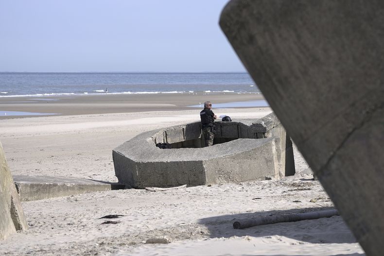 Un gendarme se ve en un búnker nazi de la IIGM en la playa de Ecault, el viernes 4 de julio de 2025. (AP Foto/John Leicester)