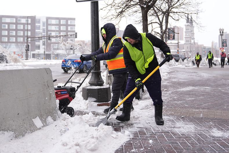 Trabajadores despejan nieve del suelo el domingo 15 de marzo de 2026 en St. Paul, Minnesota. (AP Foto/Abbie Parr)