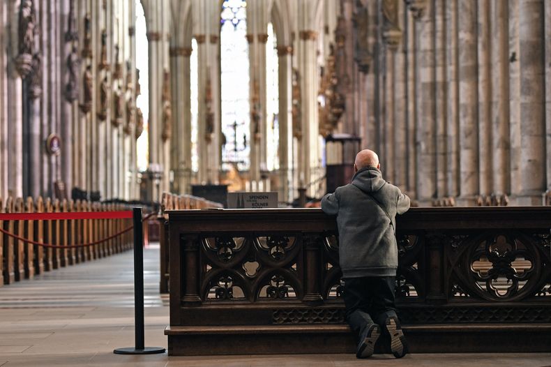 En esta imagen de archivo, un hombre reza en la catedral de Colonia, vacía, en Colonia, Alemania, el 15 de marzo de 2020. (AP Foto/Martin Meissner, File)