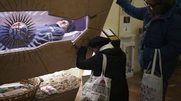 Gente rezando ante el cuerpo de Carlo Acutis, un chico italiano de 15 años que murió en 2006 de leucemia y fue beatificado en 2020, en la iglesia de Santa María Mayor en Asís, el miércoles 2 de abril de 2025. (AP Foto/Alessandra Tarantino)
