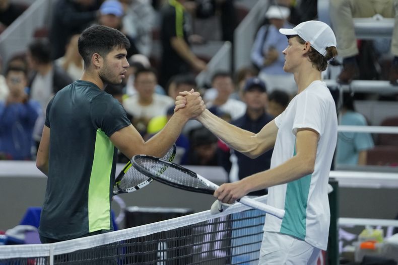 Jannik Sinner (derecha) saluda a Carlos Alcaraz tras la victoria de Sinner en las semifinales del Abierto de China, el martes 3 de octubre de 2023, en Beijing. (AP Foto/Andy Wong)