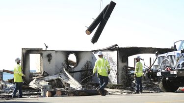 Trabajadores de Southern California Edison retiran un poste de energía carbonizado después del incendio Palisades en Malibú, California, el domingo 12 de enero de 2025. (Scott Strazzante/San Francisco Chronicle via AP)